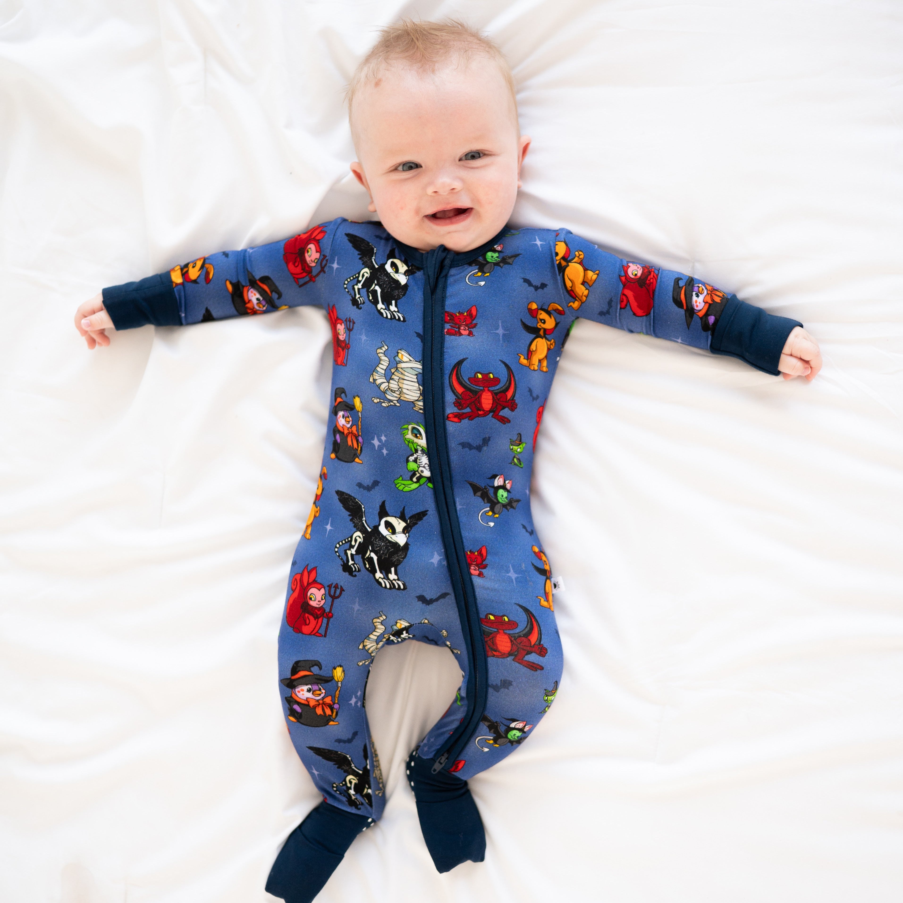 Baby in a blue Halloween-themed zippered pajama with Neopets characters.