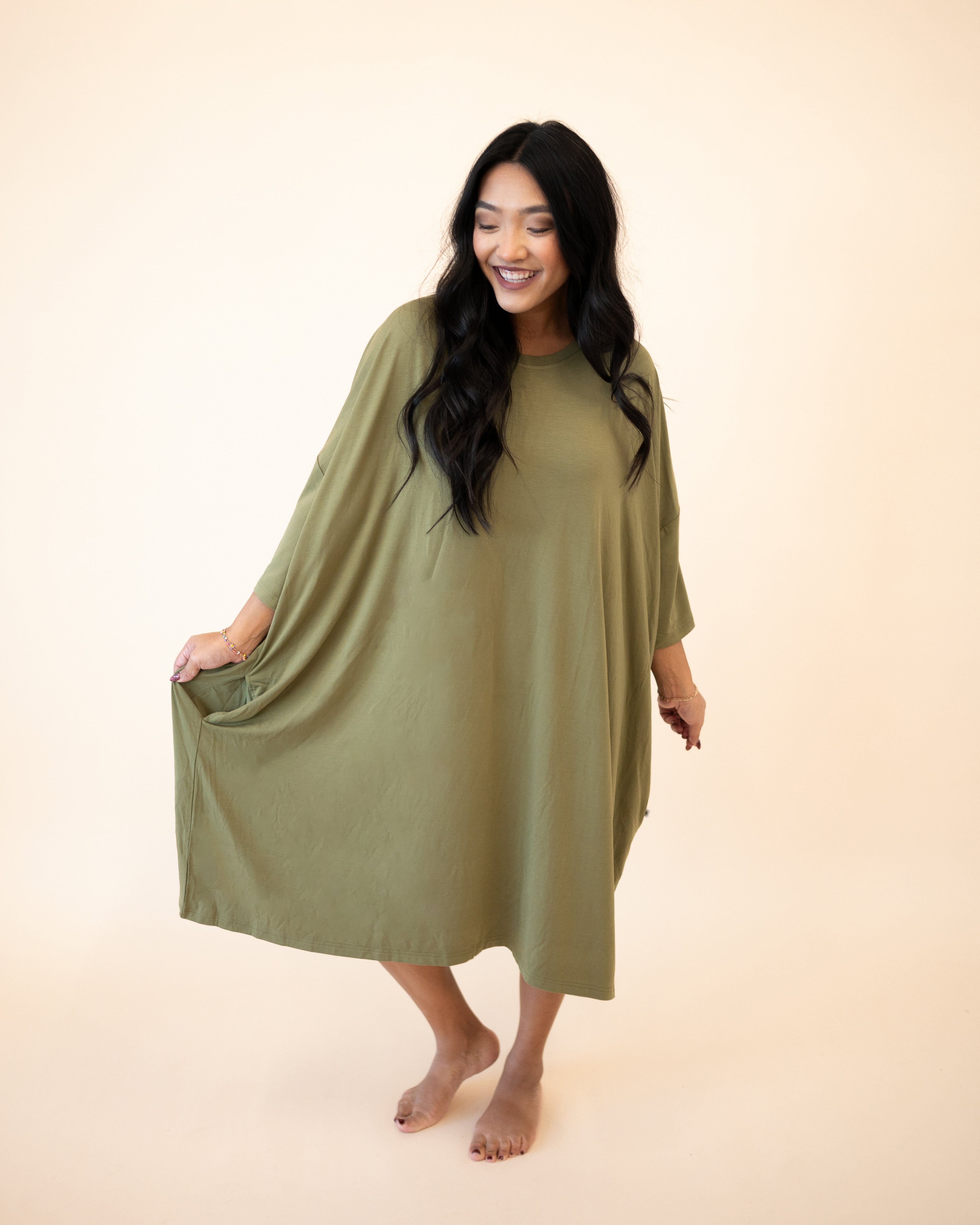 A woman in an olive green Tencel Modal mega sleep tee with pockets.