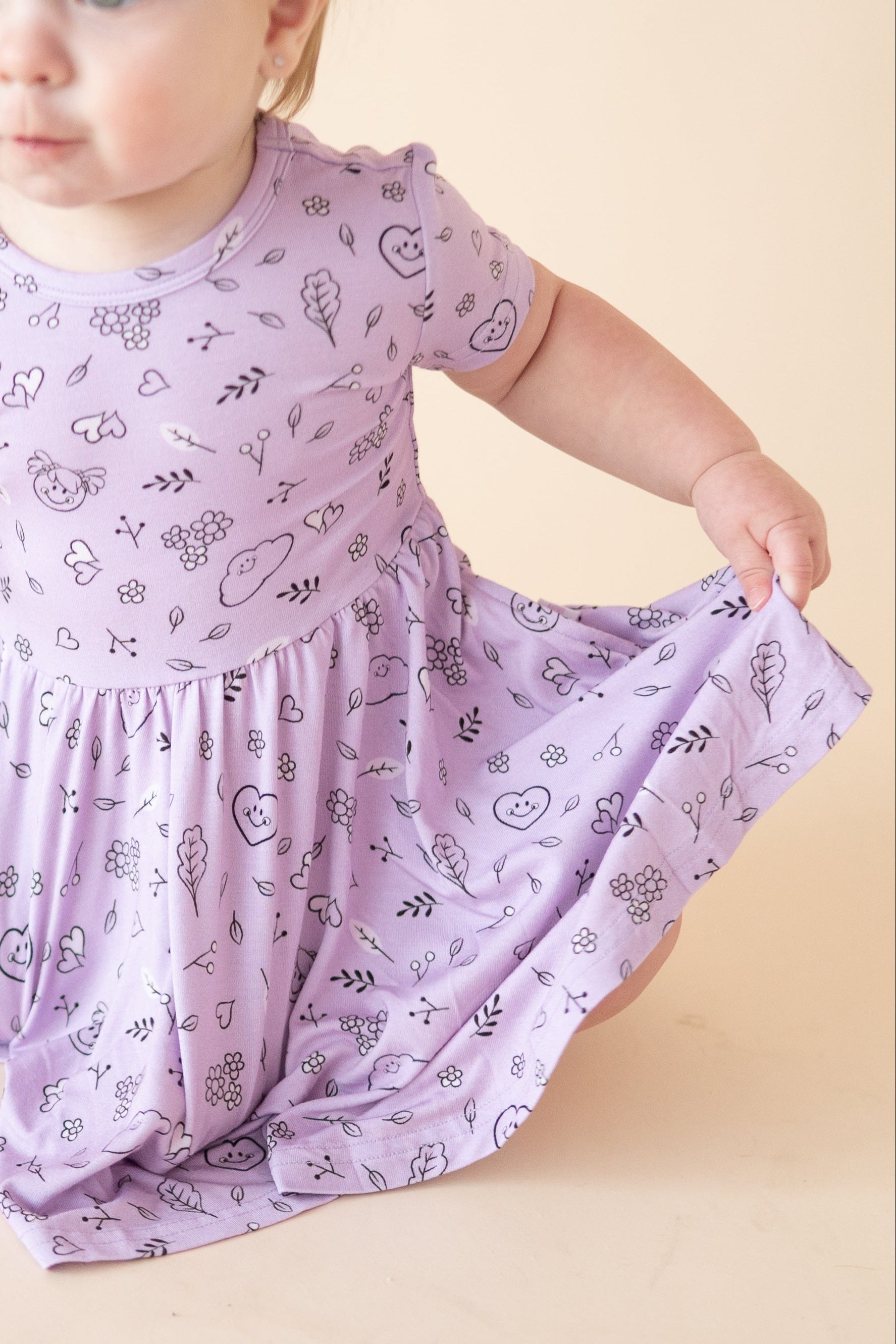 A lilac dress with a doodle print and smiley faces.