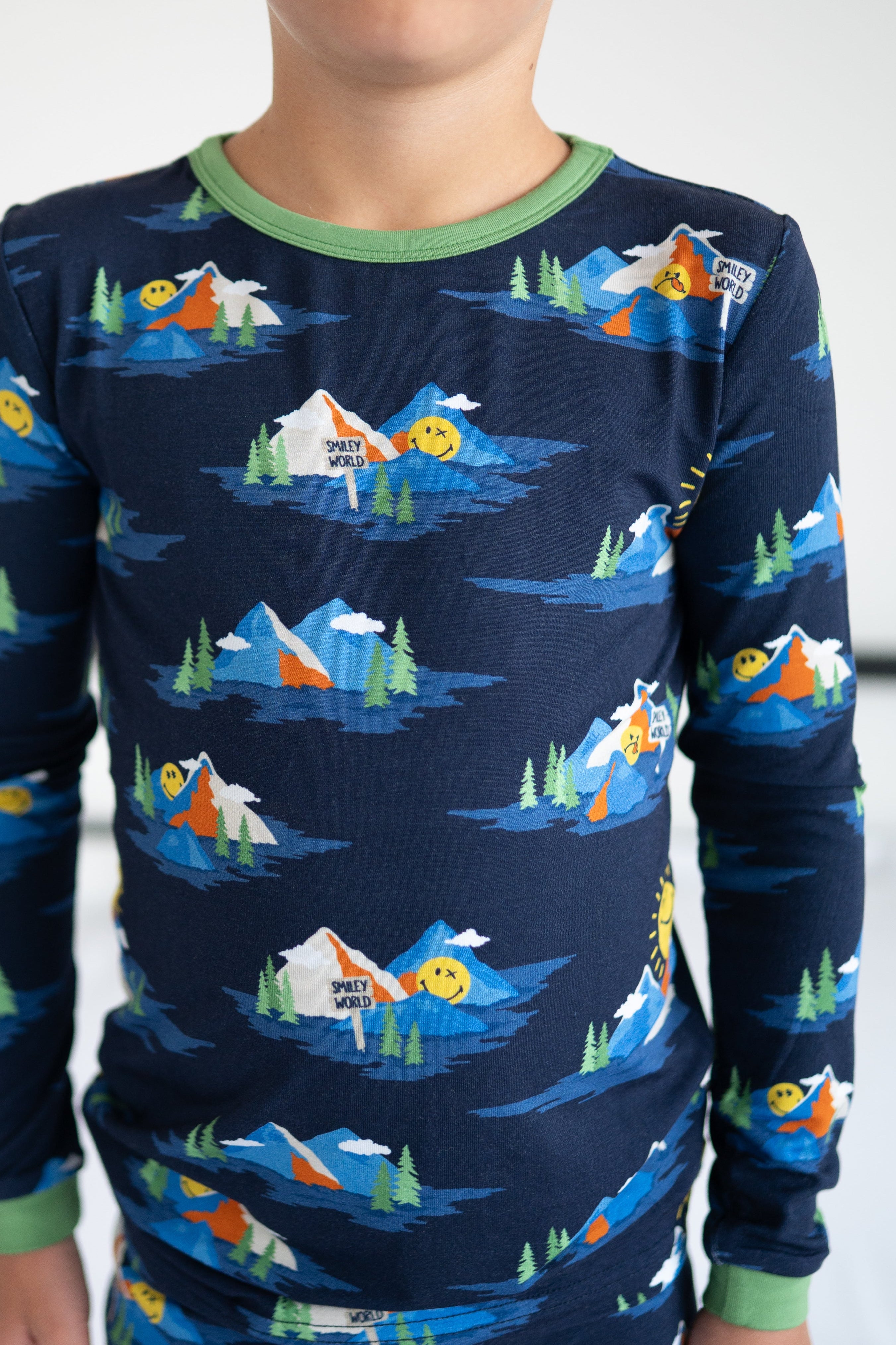 A navy blue long-sleeved pajama top with a repeating print of mountains, trees, and smiley faces.