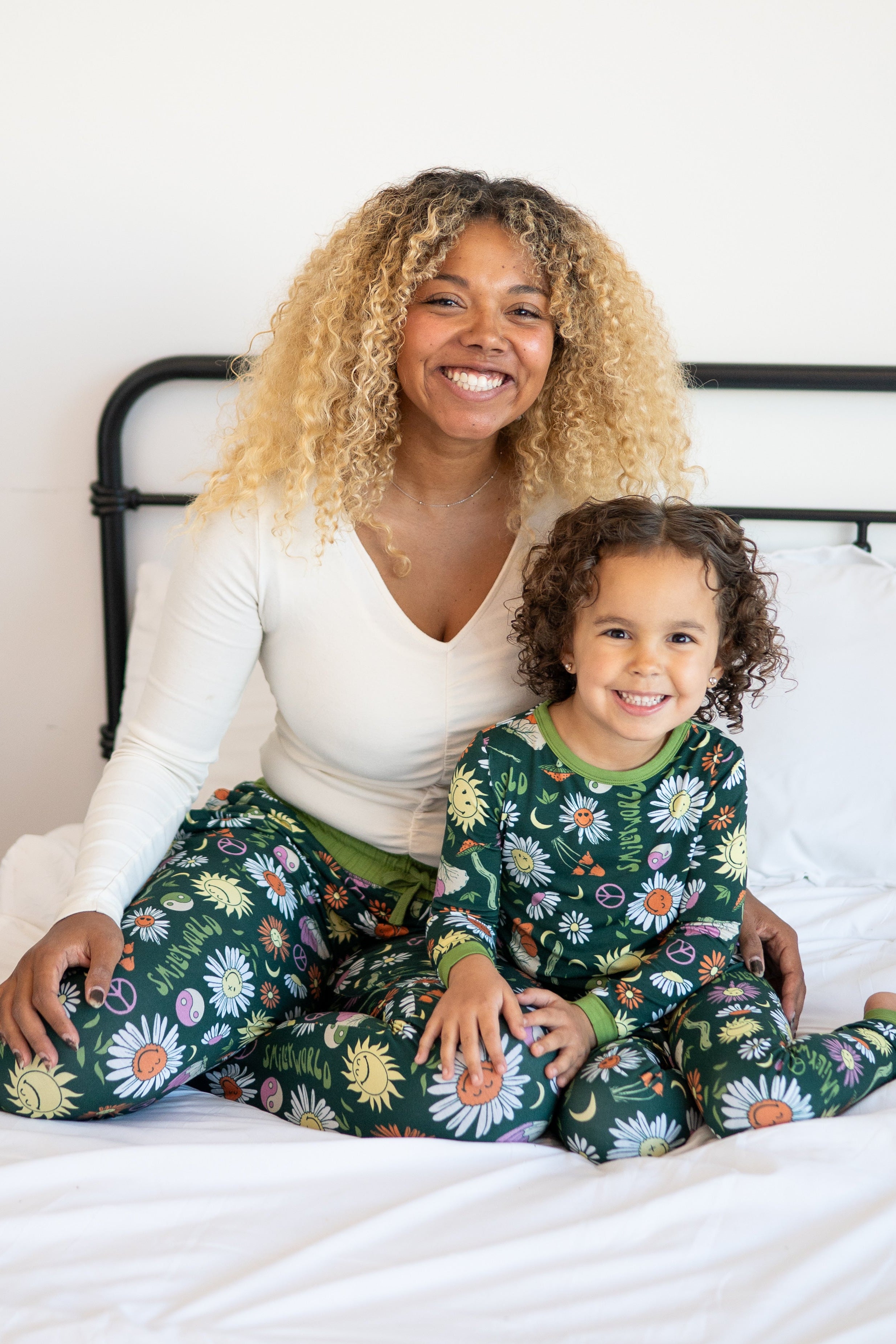 A woman and child in matching green pajamas with a groovy floral SmileyWorld print.