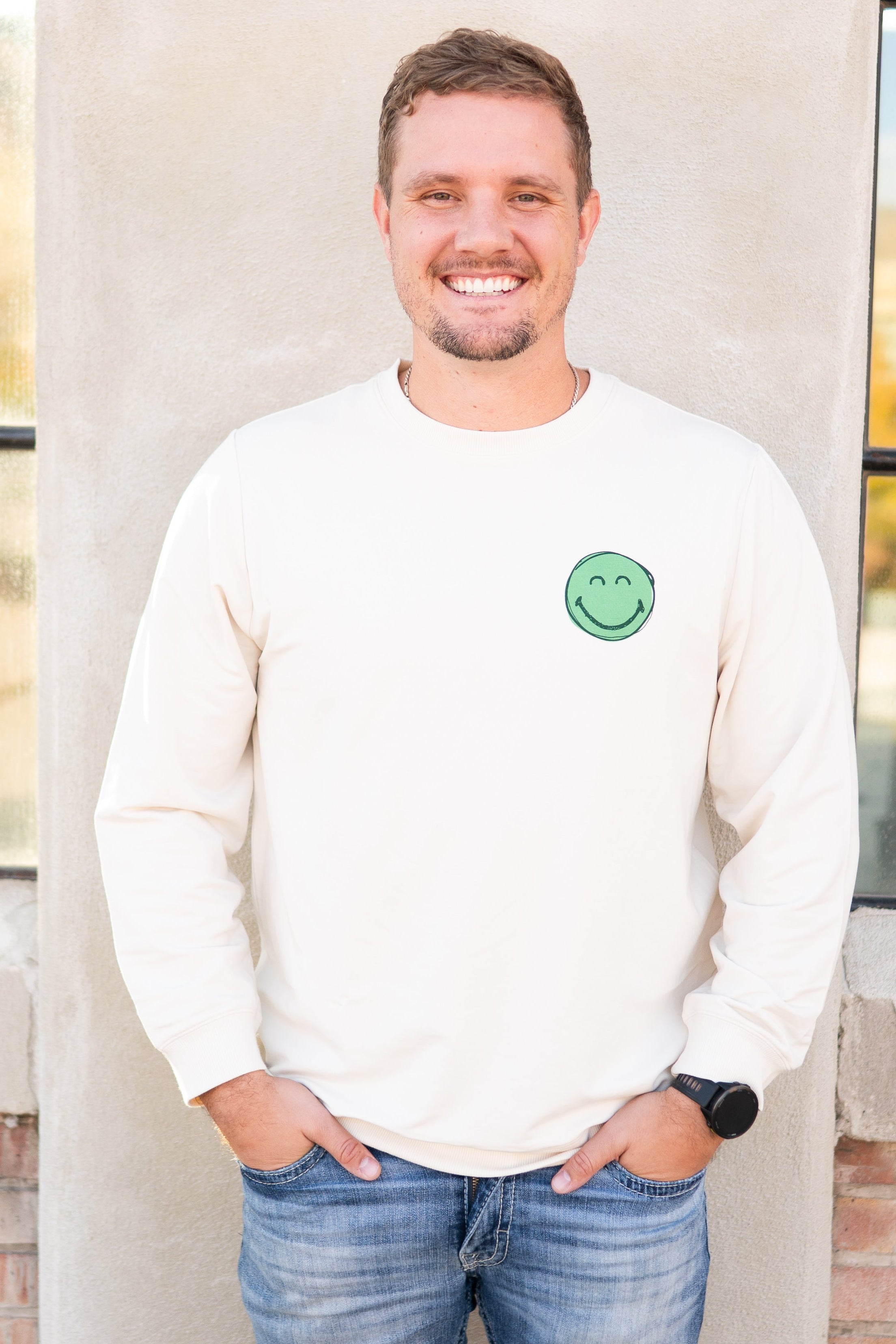 Adult unisex crewneck sweatshirt with a green smiley face graphic.