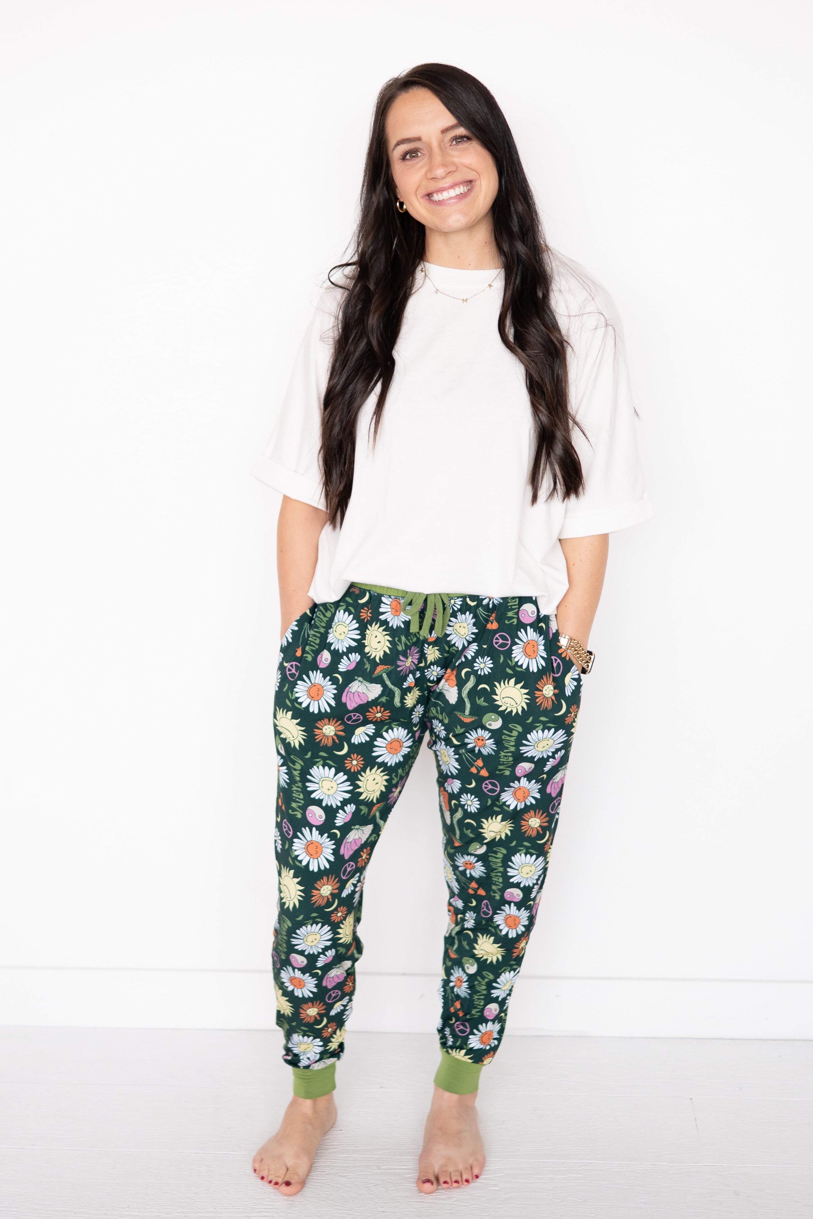 Women's dark green joggers with a colorful SmileyWorld® groovy floral print.