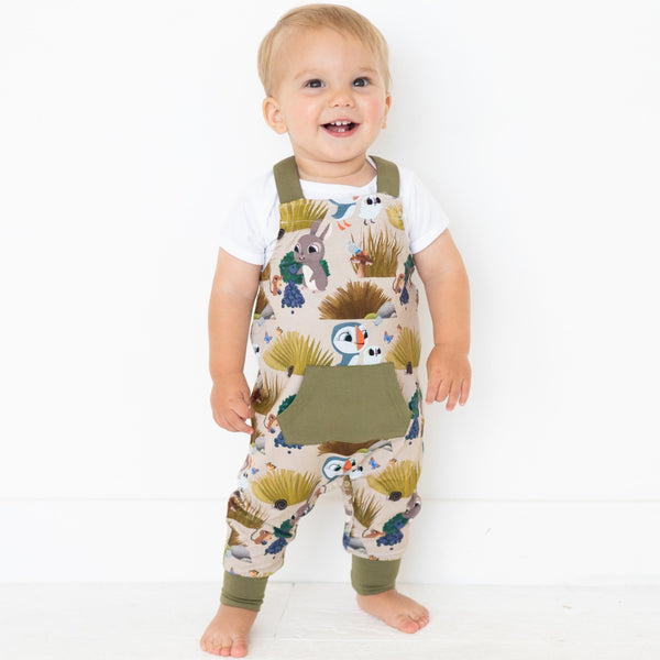 Toddler overalls with a Puffin Rock print and olive green pocket.