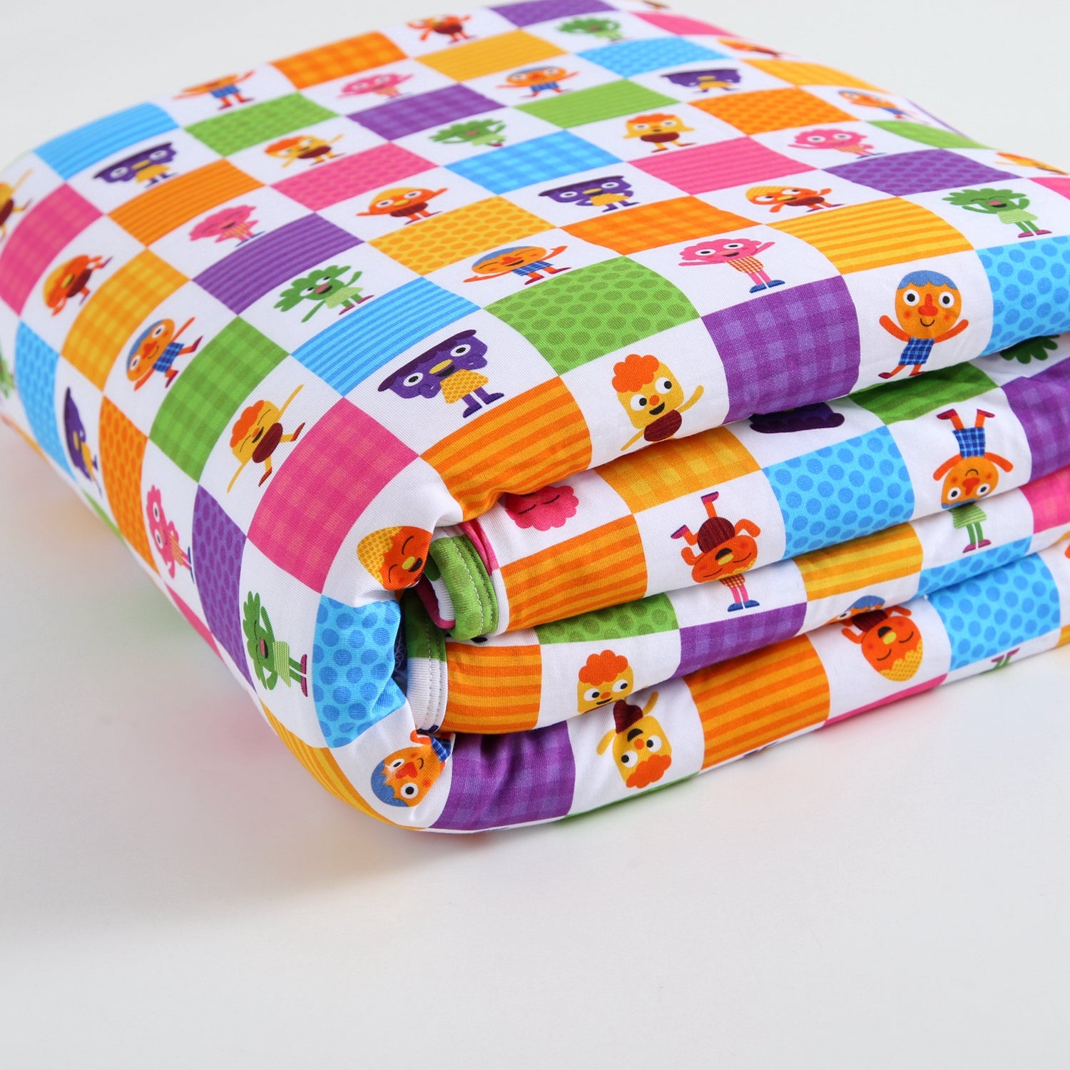 A folded plush blanket with a colorful checkerboard pattern featuring cartoon characters.