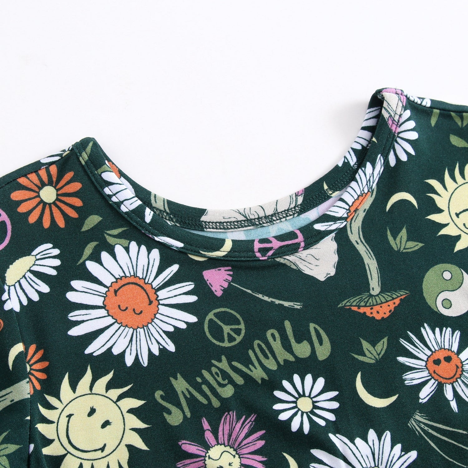 Dark green long sleeve top with a SmileyWorld groovy floral print.